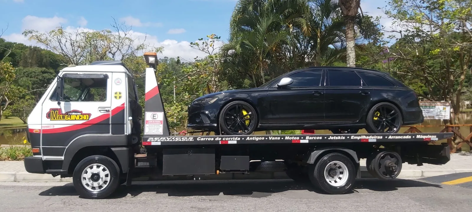 Guincho plataforma da Max Guinchos - Resgate Total transportando um carro preto